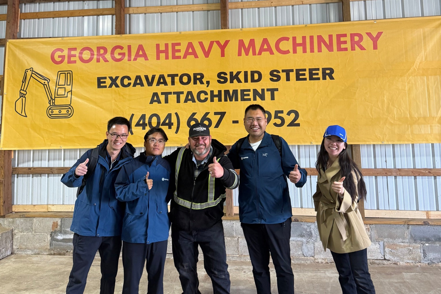 RIPPA visitors and the GHM team together in front of the Georgia Heavy Machinery banner